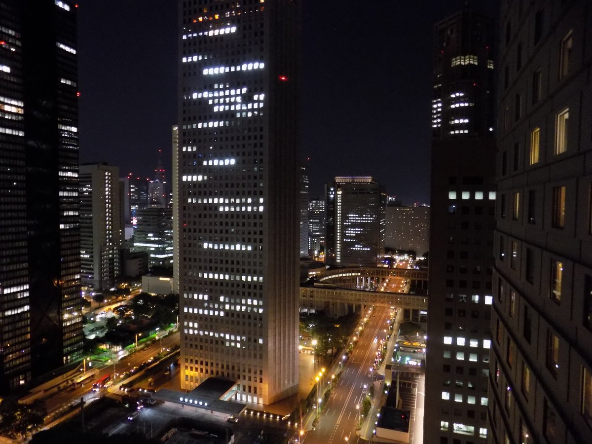 夜の西新宿の高層ビル群。オフィスの窓に明かりがともっている