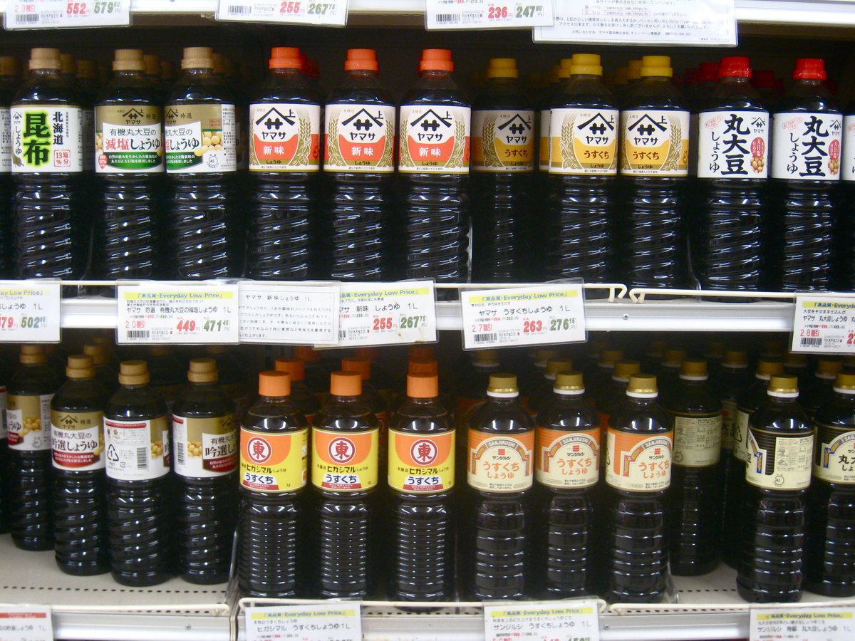日本のスーパーのたなにならぶ、しょうゆのびんと値段のふだ