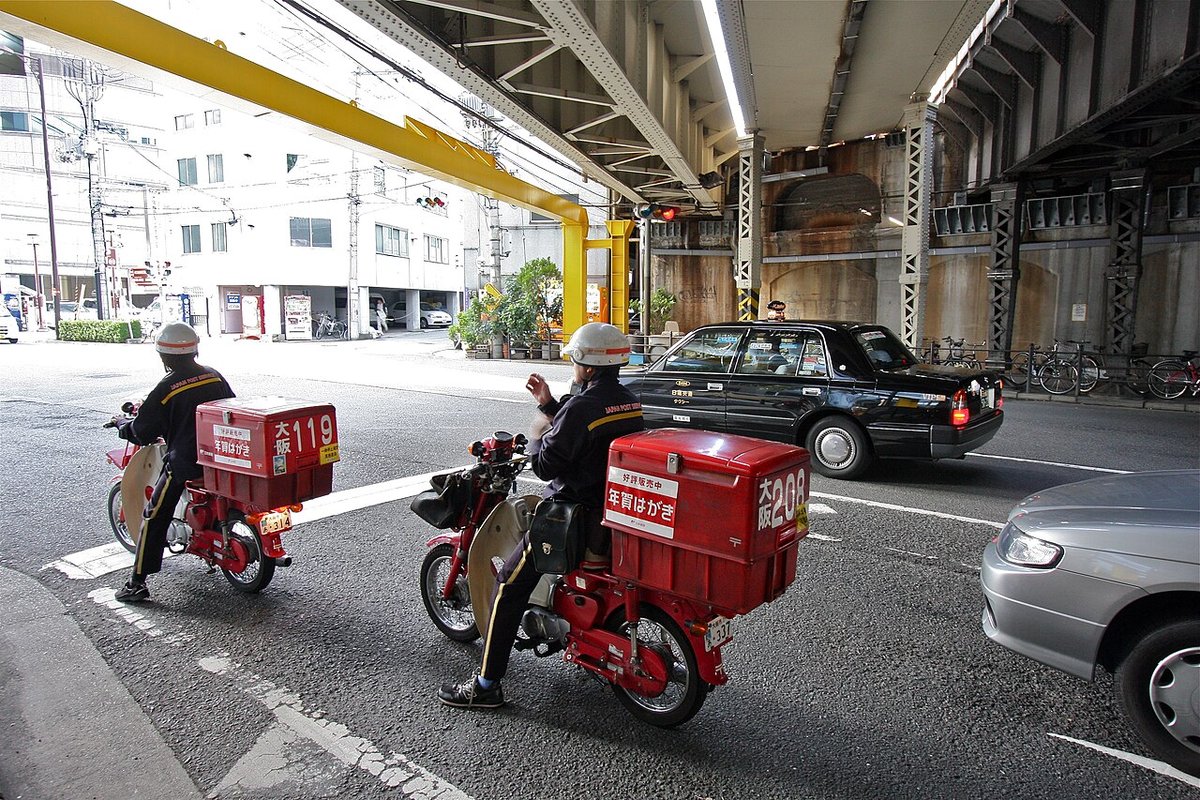 「年賀はがき」と書かれた箱をのせた郵便局のバイク（大阪、2009年）