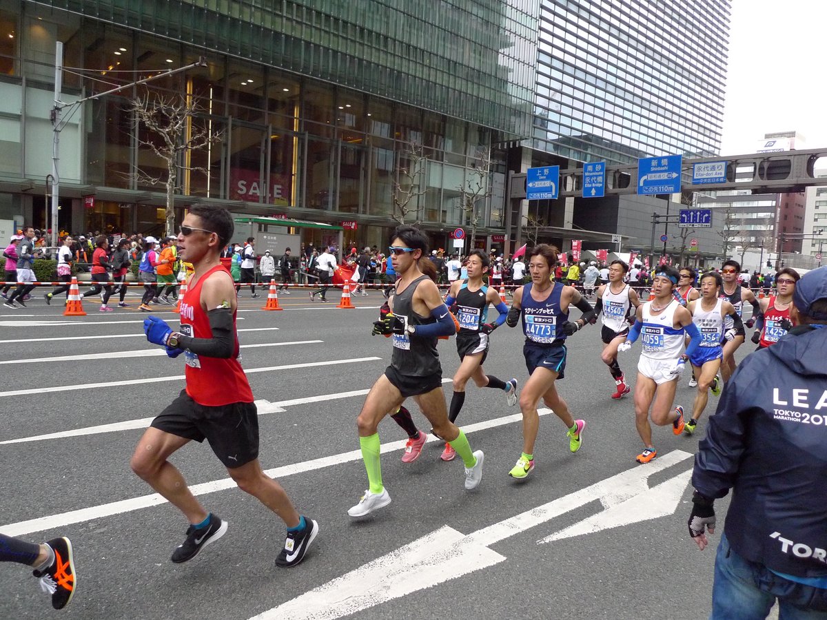 東京の町の道を走る、マラソンの人たち